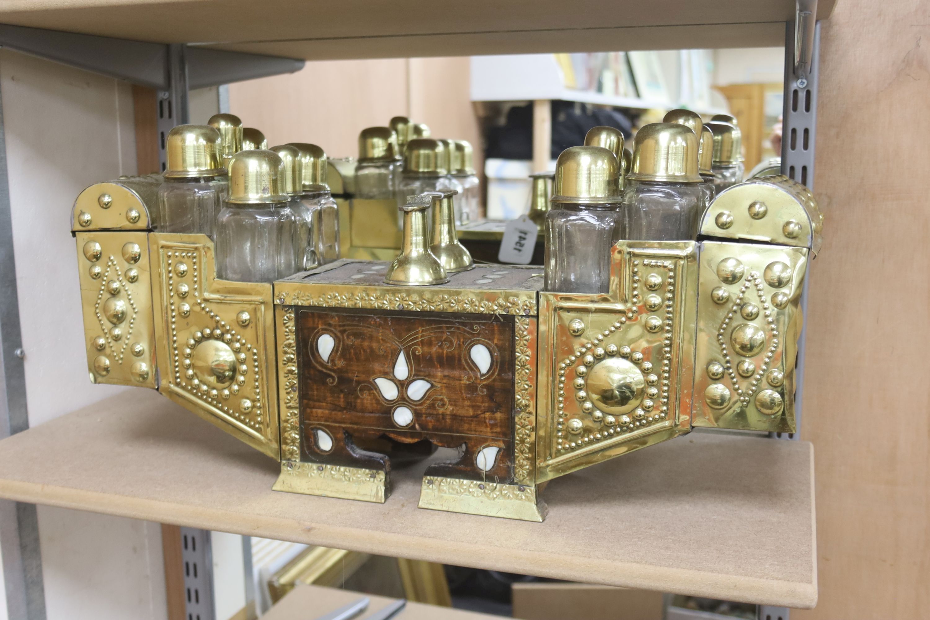 An Indian brass & hardwood shoe shiner's set, with twelve flasks. 57cm. long. 15cm. deep. 28cm. high